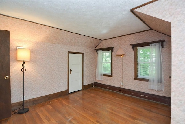 241 Fisher St, Walpole, MA 02081 - unfurnished room featuring vaulted ceiling, wood finished floors, wallpapered walls, and ornamental molding