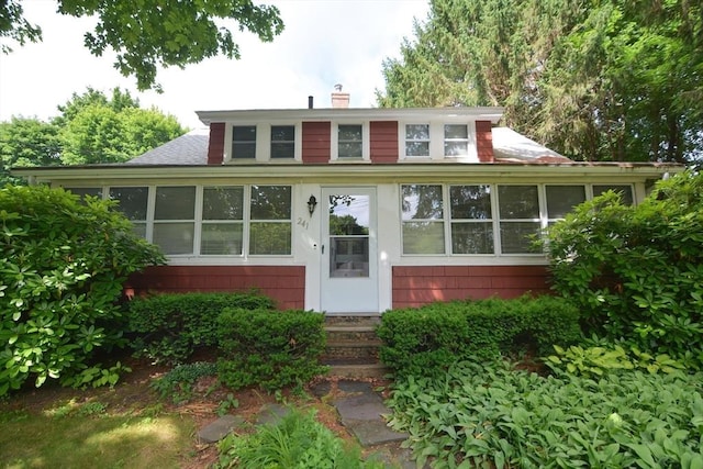 241 Fisher St, Walpole, MA 02081 - view of front of property with entry steps, a chimney, a sunroom, and roof with shingles