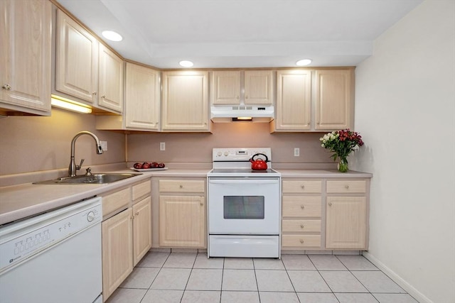 kitchen with white appliances, under cabinet range hood, a sink, light brown cabinets, and recessed lighting