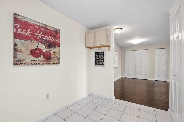 spare room featuring baseboards and light tile patterned floors