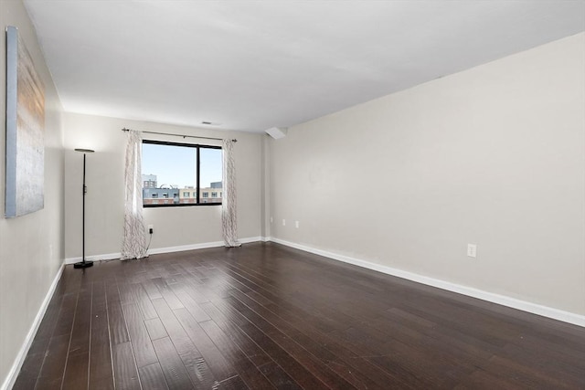 spare room featuring hardwood / wood-style floors and baseboards