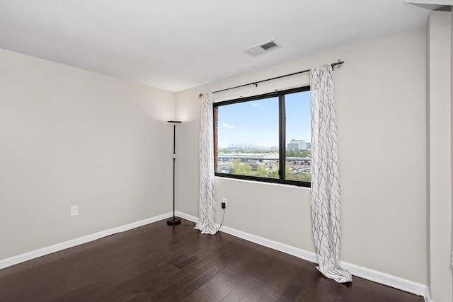 empty room with baseboards and wood finished floors