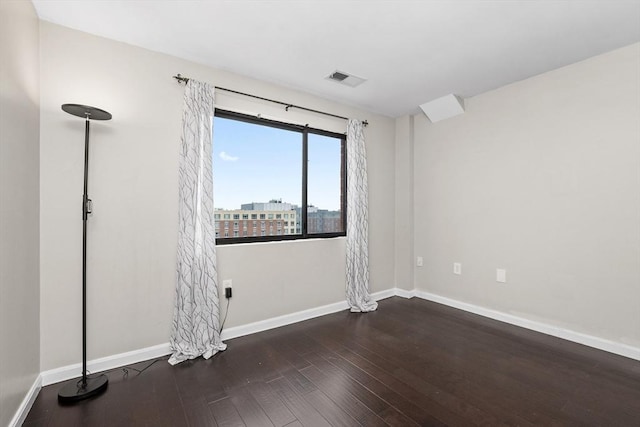 spare room with wood finished floors and baseboards