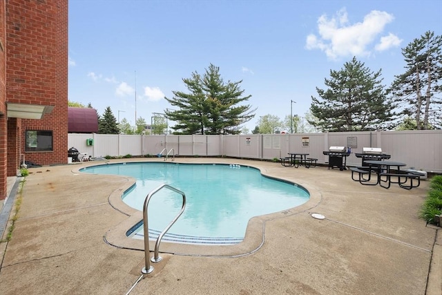 view of pool featuring a patio, fence, and grilling area