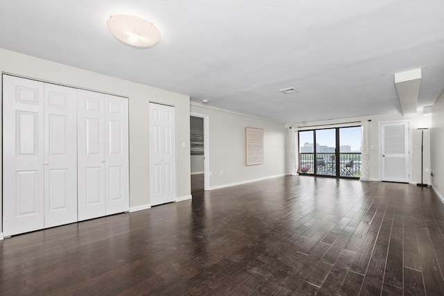 unfurnished living room with wood finished floors and baseboards