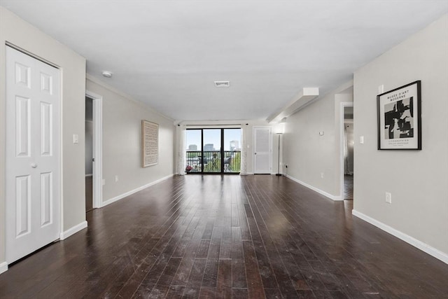 unfurnished living room with hardwood / wood-style flooring and baseboards