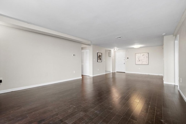 unfurnished living room with hardwood / wood-style flooring and baseboards