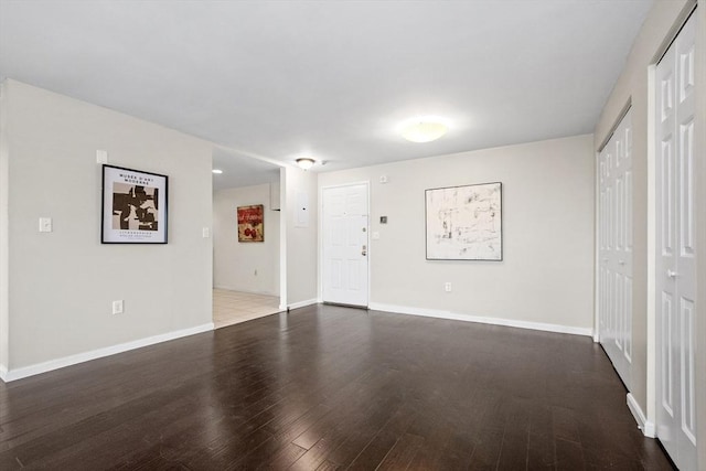 unfurnished living room with wood finished floors and baseboards