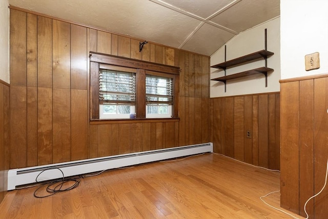 18 Balder Rd, Worcester, MA 01605 - empty room with a baseboard heating unit, wood walls, wood finished floors, lofted ceiling, and a wainscoted wall