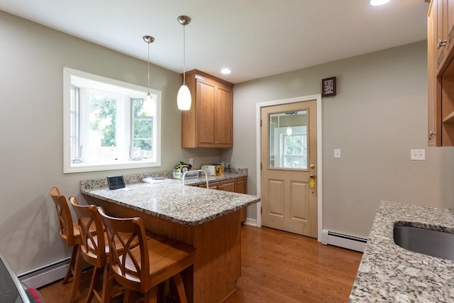 18 Balder Rd, Worcester, MA 01605 - kitchen featuring baseboard heating, a peninsula, light wood finished floors, a kitchen breakfast bar, and recessed lighting