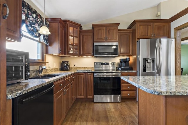 kitchen with stainless steel appliances, dark wood finished floors, vaulted ceiling, light stone countertops, and a sink