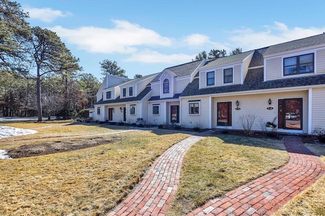 view of front of property with a front lawn and roof with shingles