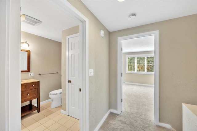 bathroom with toilet, tile patterned flooring, vanity, and baseboards