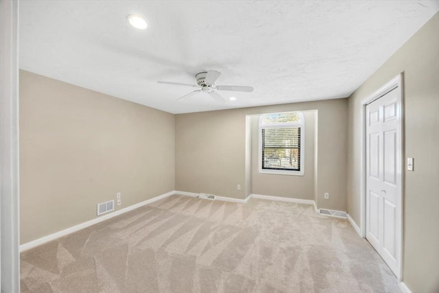 spare room featuring recessed lighting, visible vents, light carpet, ceiling fan, and baseboards