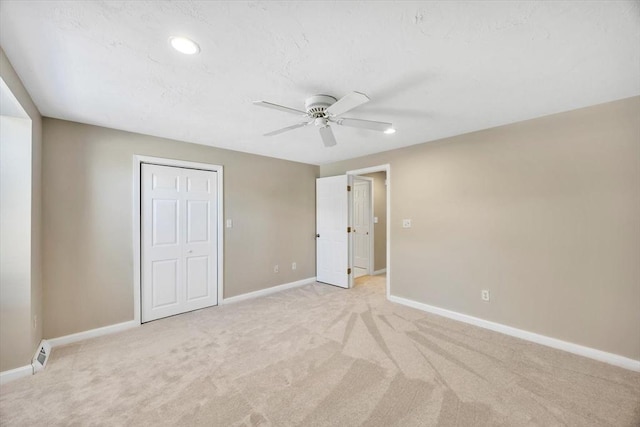 unfurnished bedroom featuring a ceiling fan, recessed lighting, light colored carpet, and baseboards