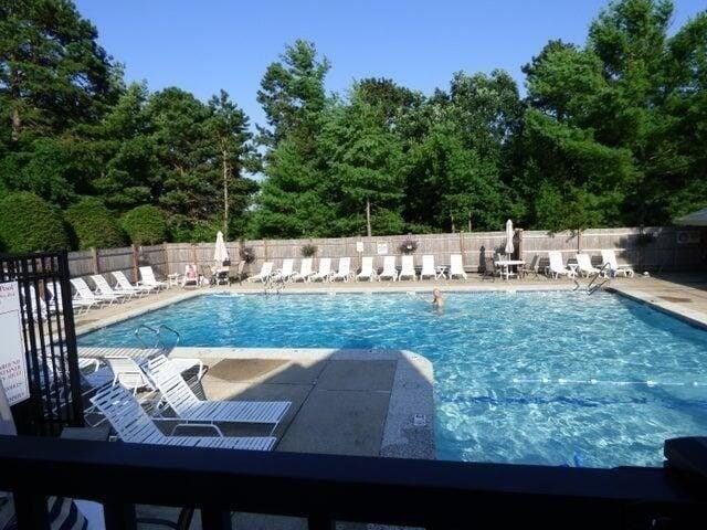 pool with a patio area and fence