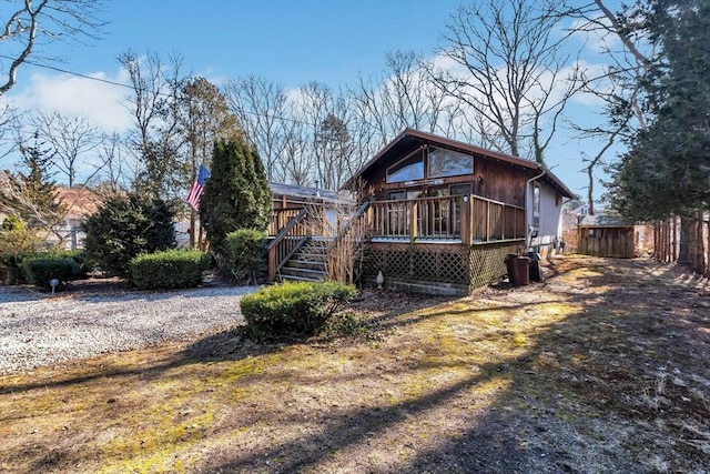 rear view of house with stairway and a wooden deck