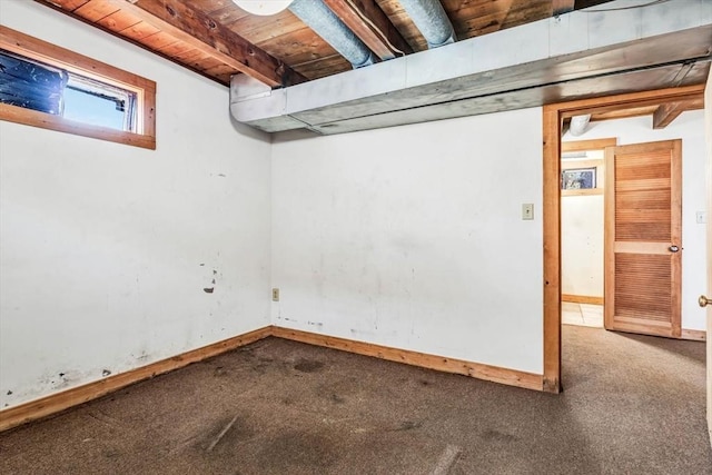 basement featuring wood ceiling, carpet, and baseboards