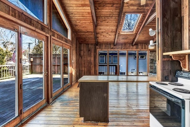 kitchen with electric stove, lofted ceiling with skylight, wood ceiling, wooden walls, and hardwood / wood-style floors