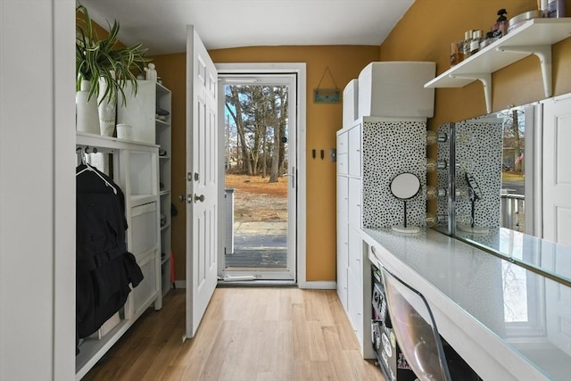 entryway with baseboards and light wood finished floors