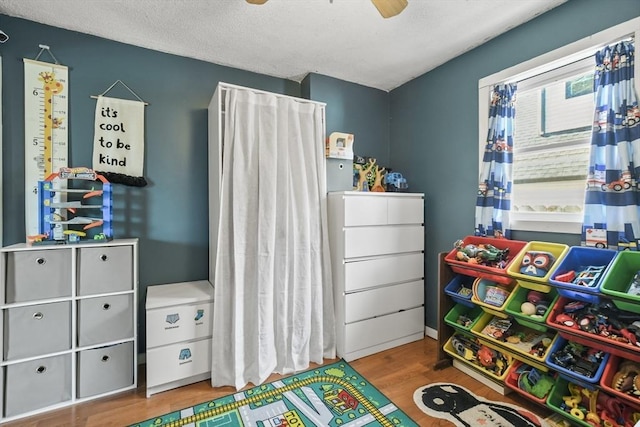 bedroom featuring a textured ceiling, wood finished floors, and a ceiling fan