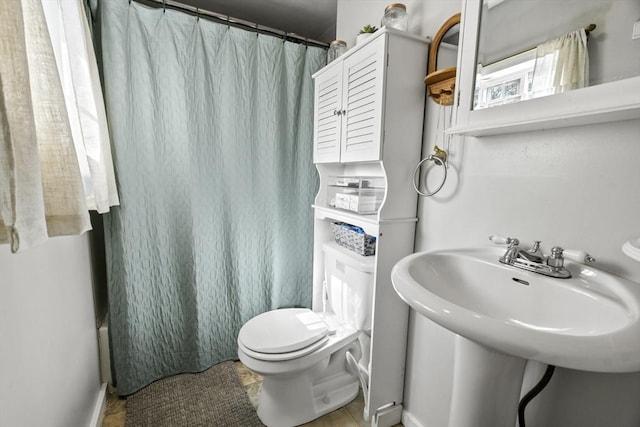 full bathroom with toilet, a shower with curtain, and a sink