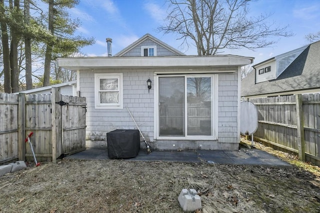 rear view of house featuring a fenced backyard