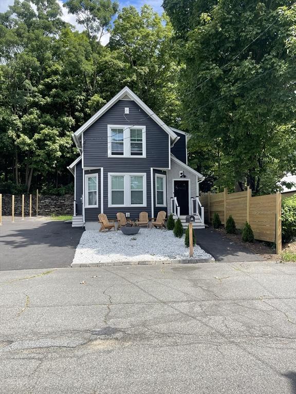 view of front of house featuring entry steps, aphalt driveway, and fence