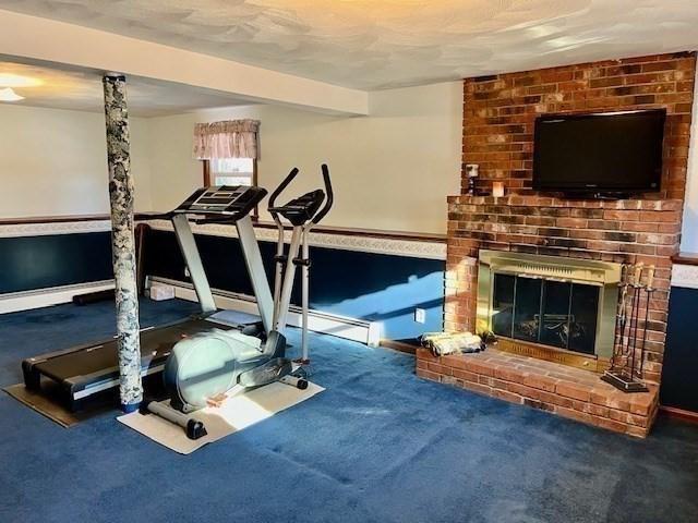 exercise area featuring carpet and a fireplace