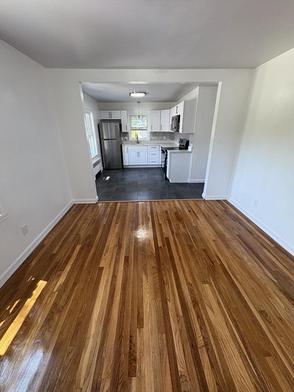 63 Bernice Ave, Brockton, MA 02301 - unfurnished living room with dark wood-style floors and baseboards
