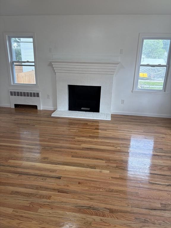 63 Bernice Ave, Brockton, MA 02301 - detailed view of radiator, wood finished floors, and a fireplace