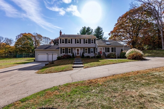 colonial house with a front yard and a garage