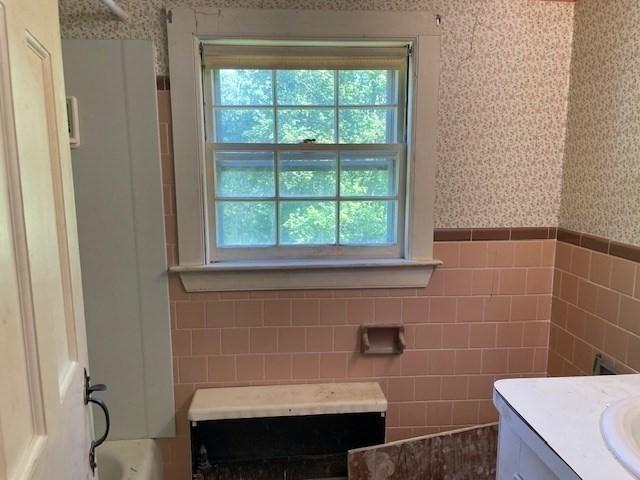 1 Pine Island Rd, Newbury, MA 01951 - full bathroom featuring tile walls, vanity, wallpapered walls, and a wainscoted wall