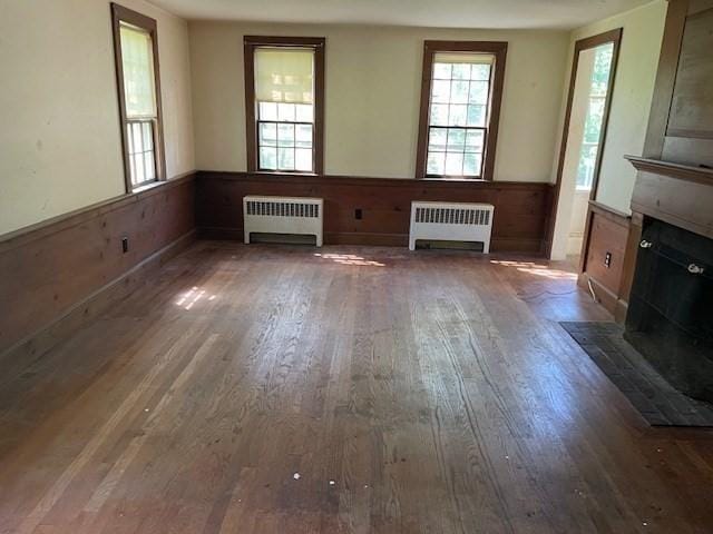 1 Pine Island Rd, Newbury, MA 01951 - unfurnished living room with radiator heating unit, wainscoting, healthy amount of natural light, and wood finished floors