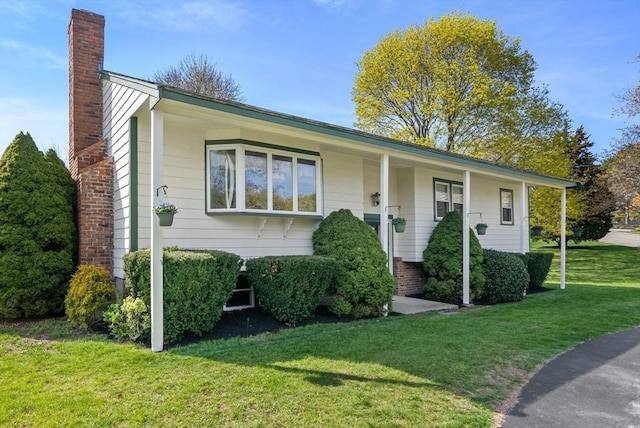 view of front of home featuring a front yard and a chimney