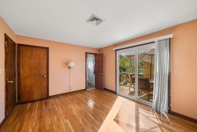 unfurnished bedroom featuring baseboards, visible vents, access to exterior, and light wood-style floors