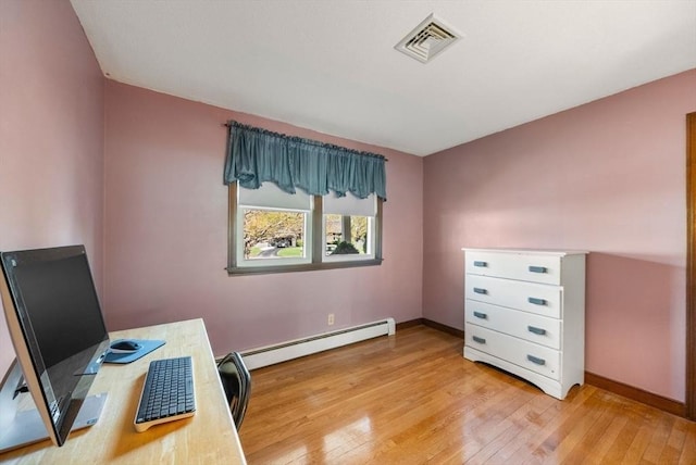 office space with baseboards, a baseboard heating unit, light wood-type flooring, and visible vents