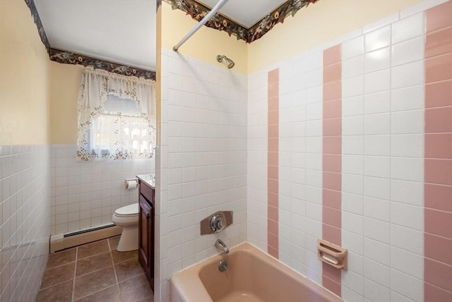 bathroom with tile walls, tile patterned flooring, a baseboard heating unit, toilet, and washtub / shower combination