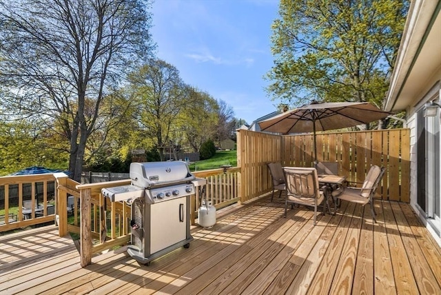 wooden terrace with outdoor dining area and area for grilling
