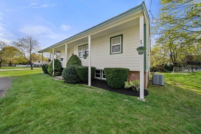 view of side of property featuring a lawn and central air condition unit