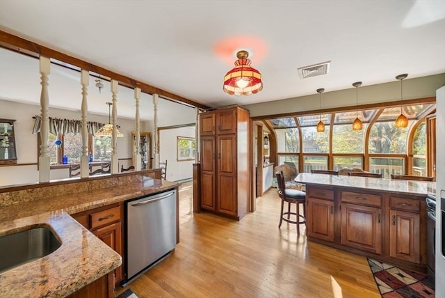 kitchen with visible vents, brown cabinetry, light wood-style flooring, and dishwasher