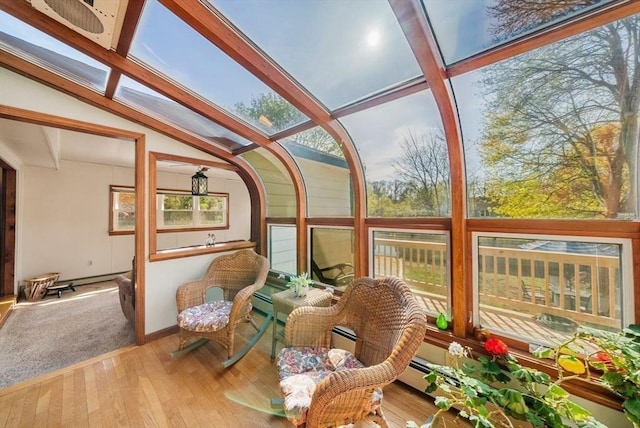sunroom / solarium featuring a baseboard radiator, vaulted ceiling with beams, plenty of natural light, and wood finished floors