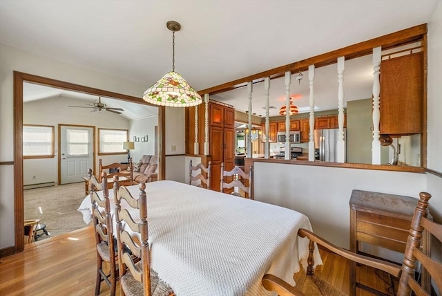 dining room with a ceiling fan, plenty of natural light, baseboard heating, and lofted ceiling