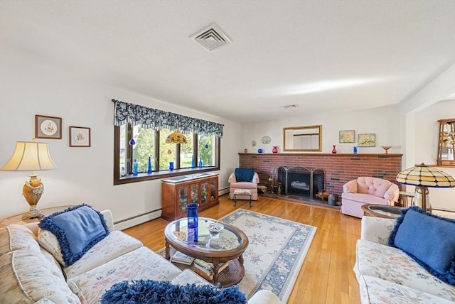 living room with baseboard heating, wood finished floors, and visible vents