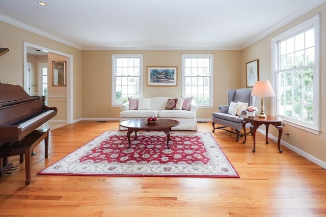 living room with a healthy amount of sunlight, wood finished floors, and ornamental molding