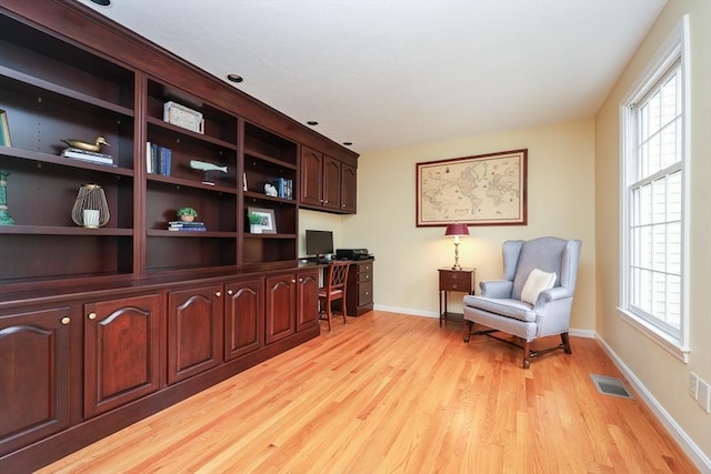 office featuring baseboards, visible vents, a wealth of natural light, and light wood-type flooring