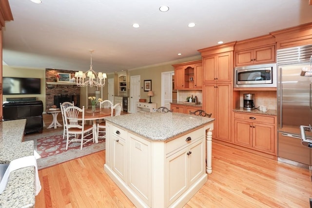 kitchen featuring tasteful backsplash, built in appliances, ornamental molding, light wood-style flooring, and recessed lighting