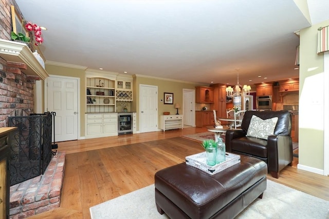 living room featuring a brick fireplace, wine cooler, light wood-style flooring, and ornamental molding