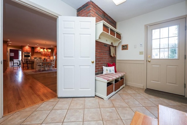 mudroom with light tile patterned floors and wainscoting