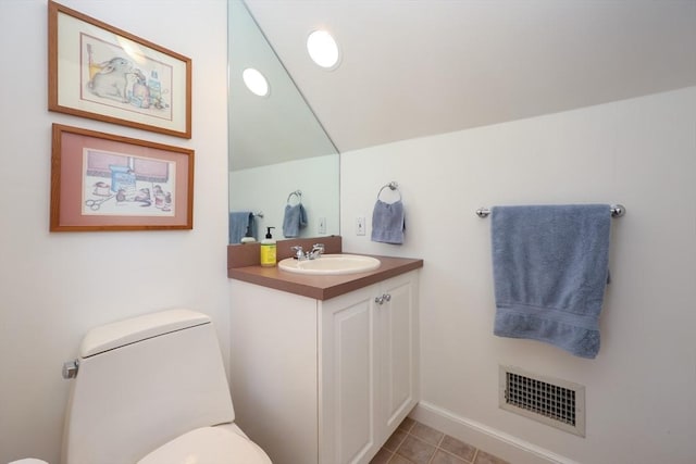 bathroom featuring tile patterned floors, visible vents, toilet, vanity, and vaulted ceiling